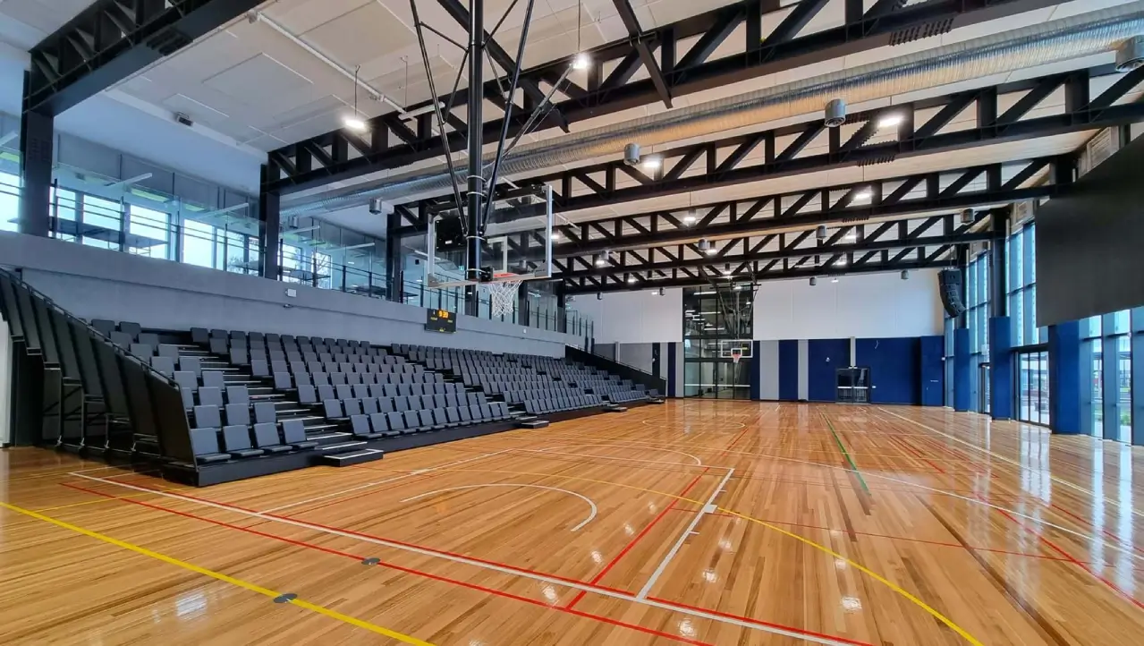 Retractable telescopic seating supplied by Profurn in a school gymnasium at Mckinnon Secondary College, Victoria